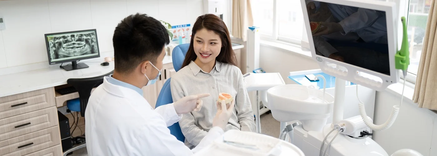 Dentist explaining treatment to a patient with a dental model