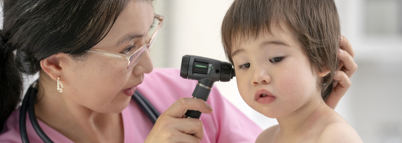 An ENT specialist examining a young child's ear