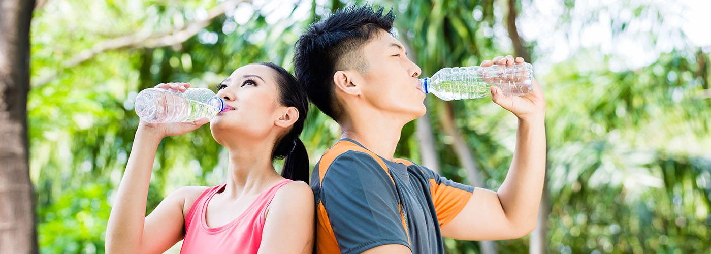 Man and woman drinking water outdoors to support kidney and urinary health